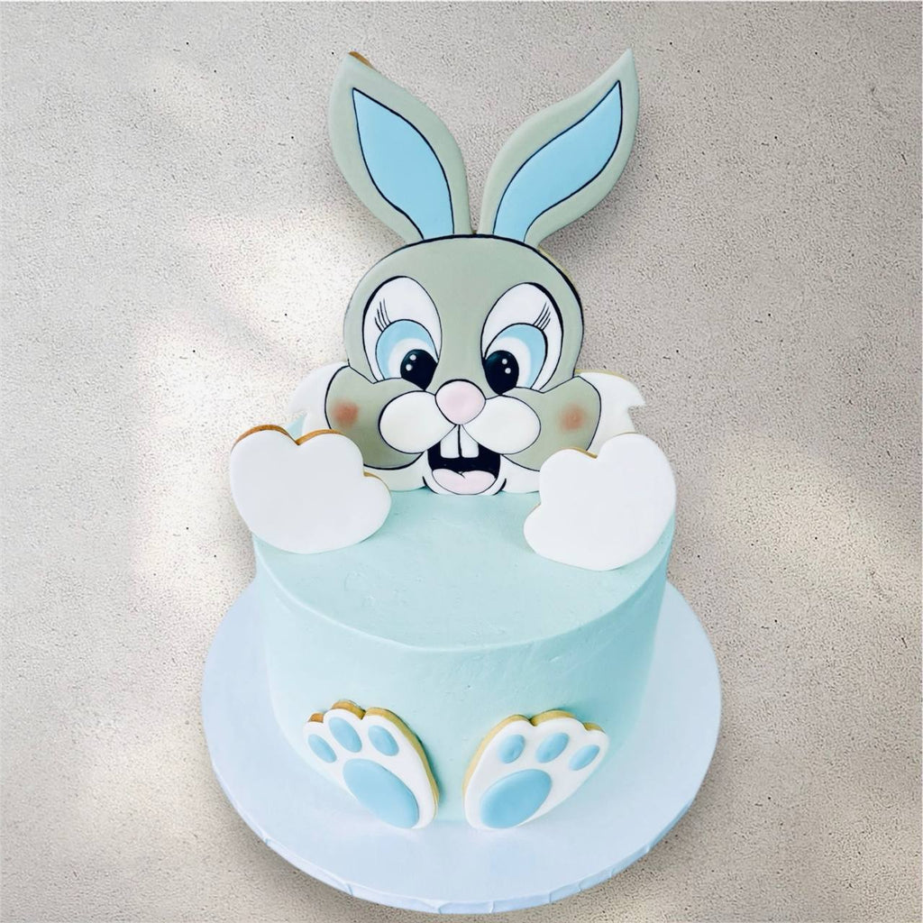 Side view of bunny-themed cake with pastel fondant ears