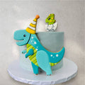 Round green dinosaur-themed birthday cake with fondant details