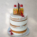 Novelty cake shaped like a whiskey bottle with red and orange flame details