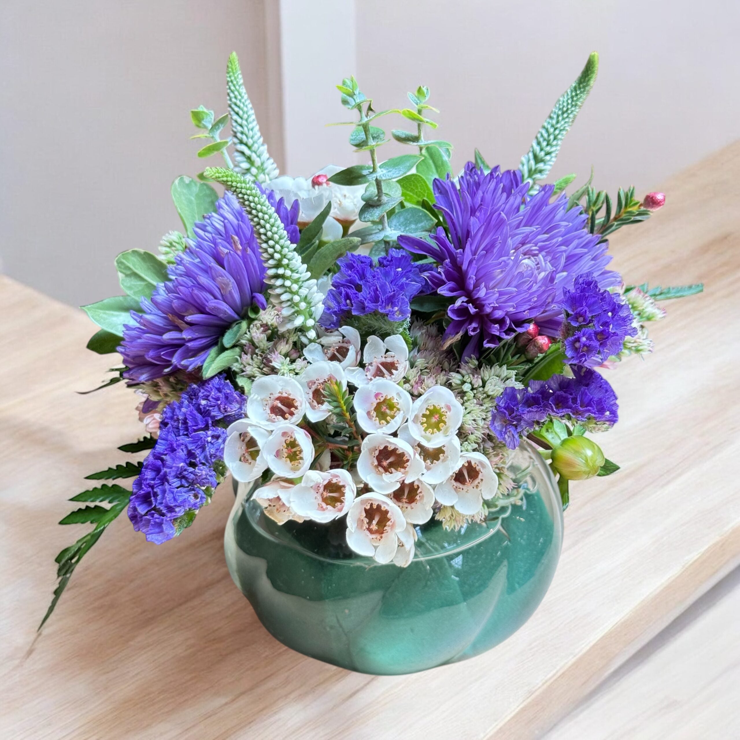 Close-up of pastel blooms in a light-filled flower arrangement