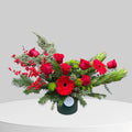 Red and green Christmas flower arrangement with holiday greenery