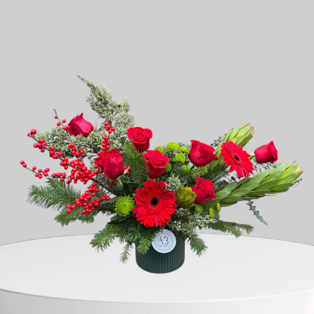 Red and green Christmas flower arrangement with holiday greenery