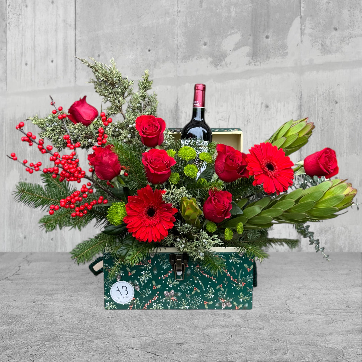 Christmas-themed gift box filled with festive flowers and greenery