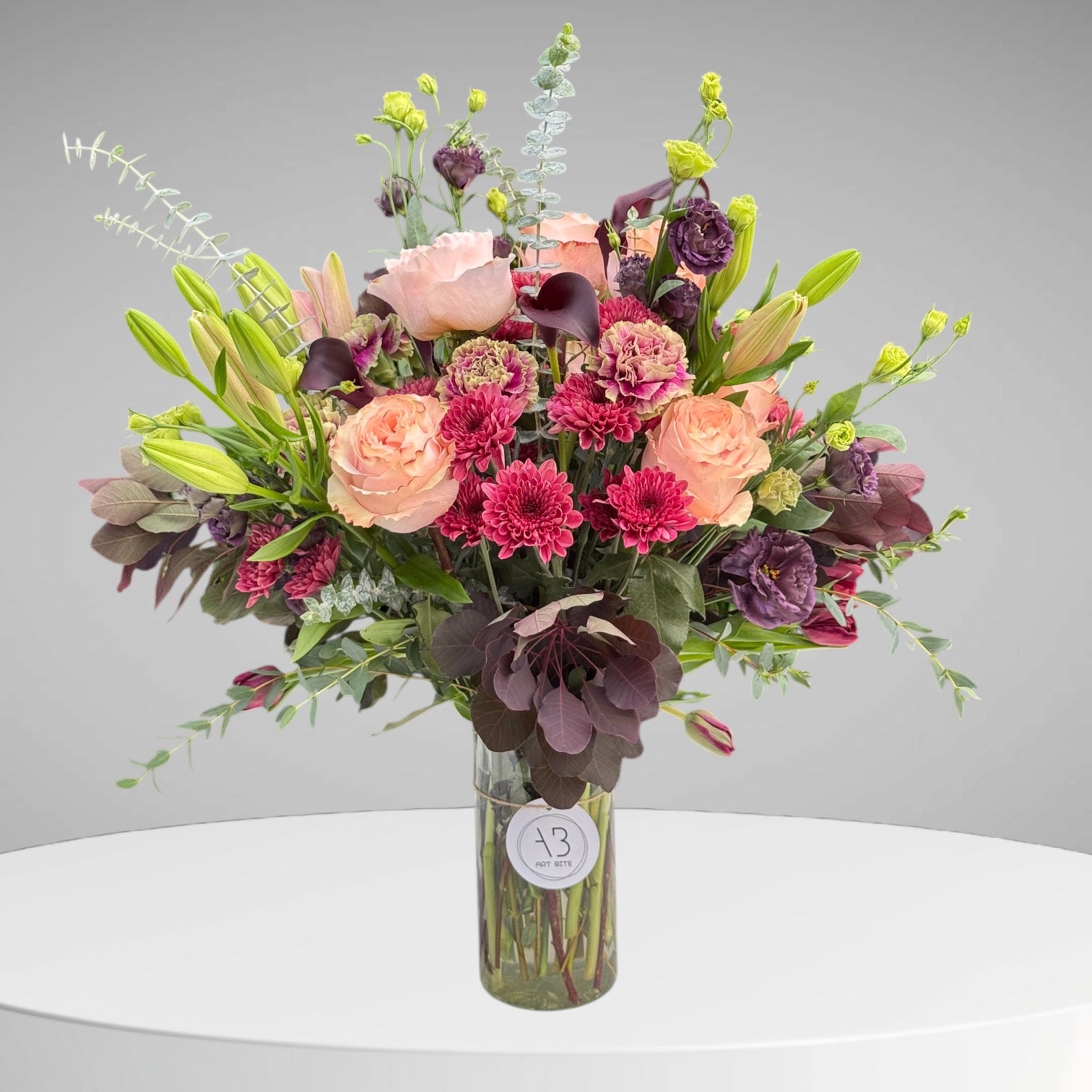 Flower arrangement combining blush pink and deep wine-red blooms