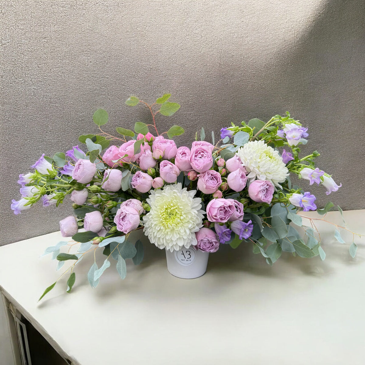 Close-up of deep purple blooms in a garden-style vase arrangement