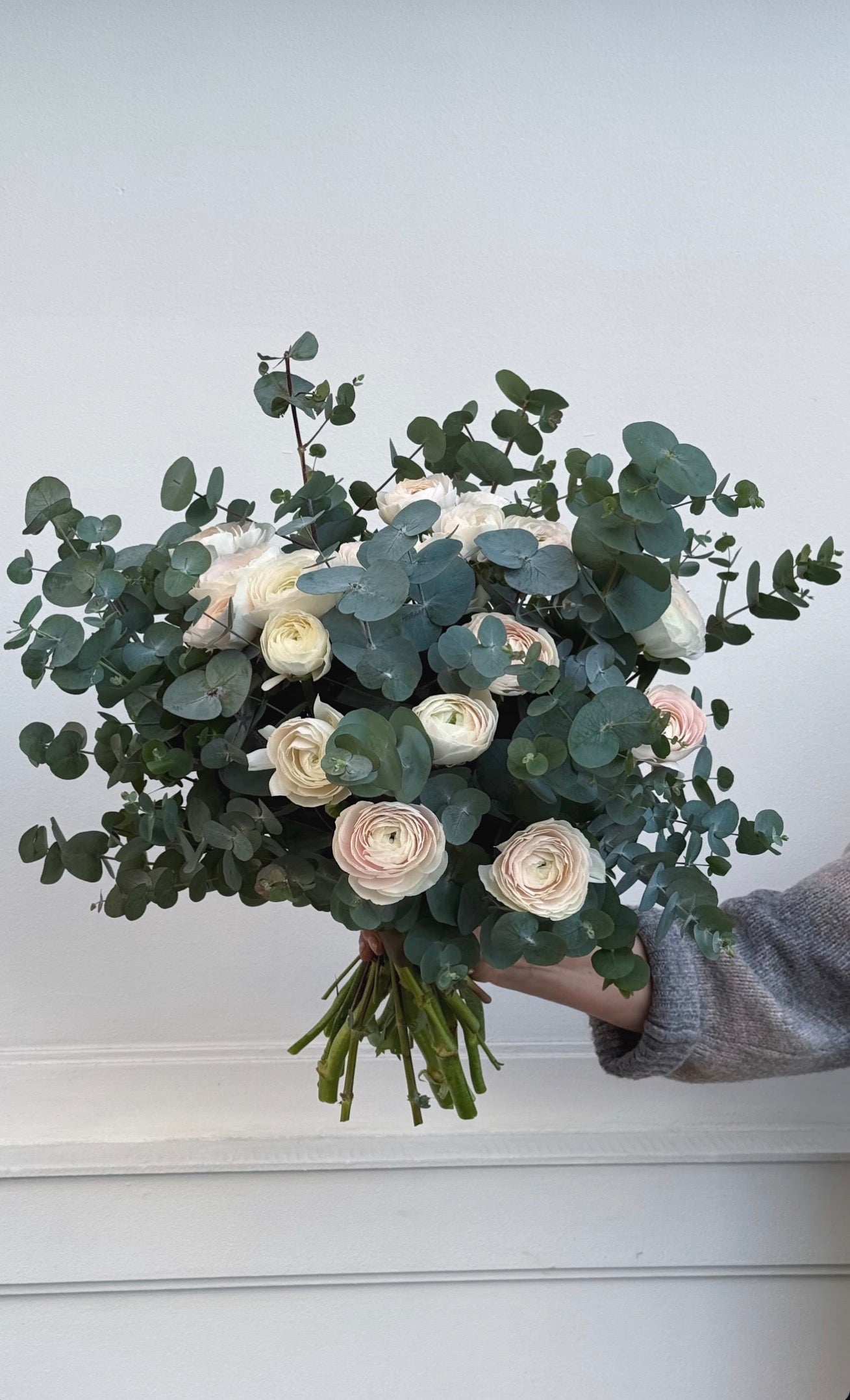 Soft pastel fresh flower bouquet wrapped in neutral paper