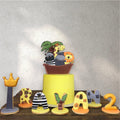 Jungle-themed birthday cake decorated with safari animals and green fondant leaves