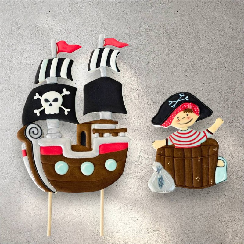 Individually decorated pirate ship cookie used as a cake topper