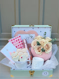 Pastel-toned flower arrangement in a gift box with soft blush and cream blooms