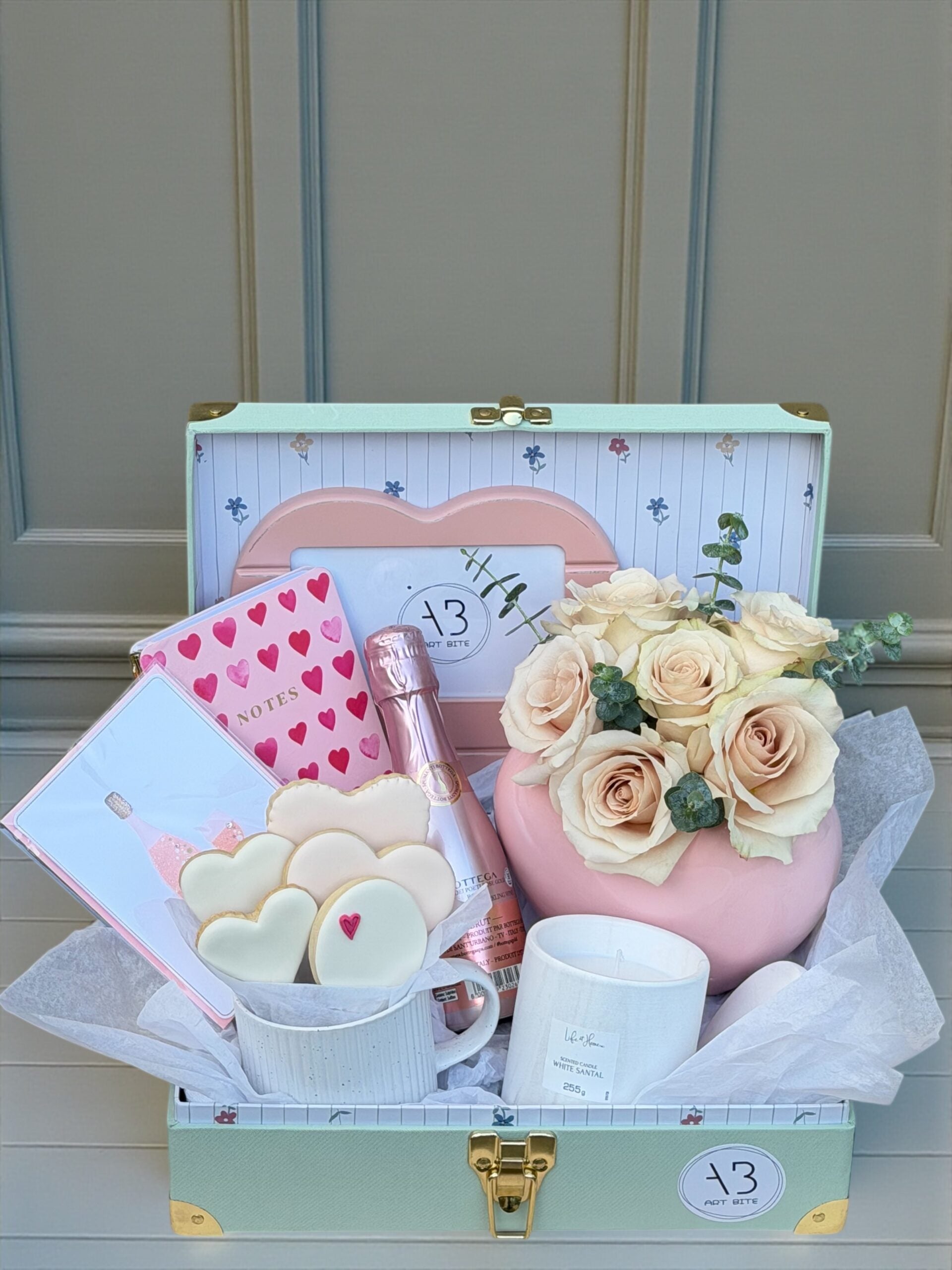 Pastel-toned flower arrangement in a gift box with soft blush and cream blooms