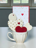 Heart-decorated cookies arranged in a gift box cup for Valentine's Day