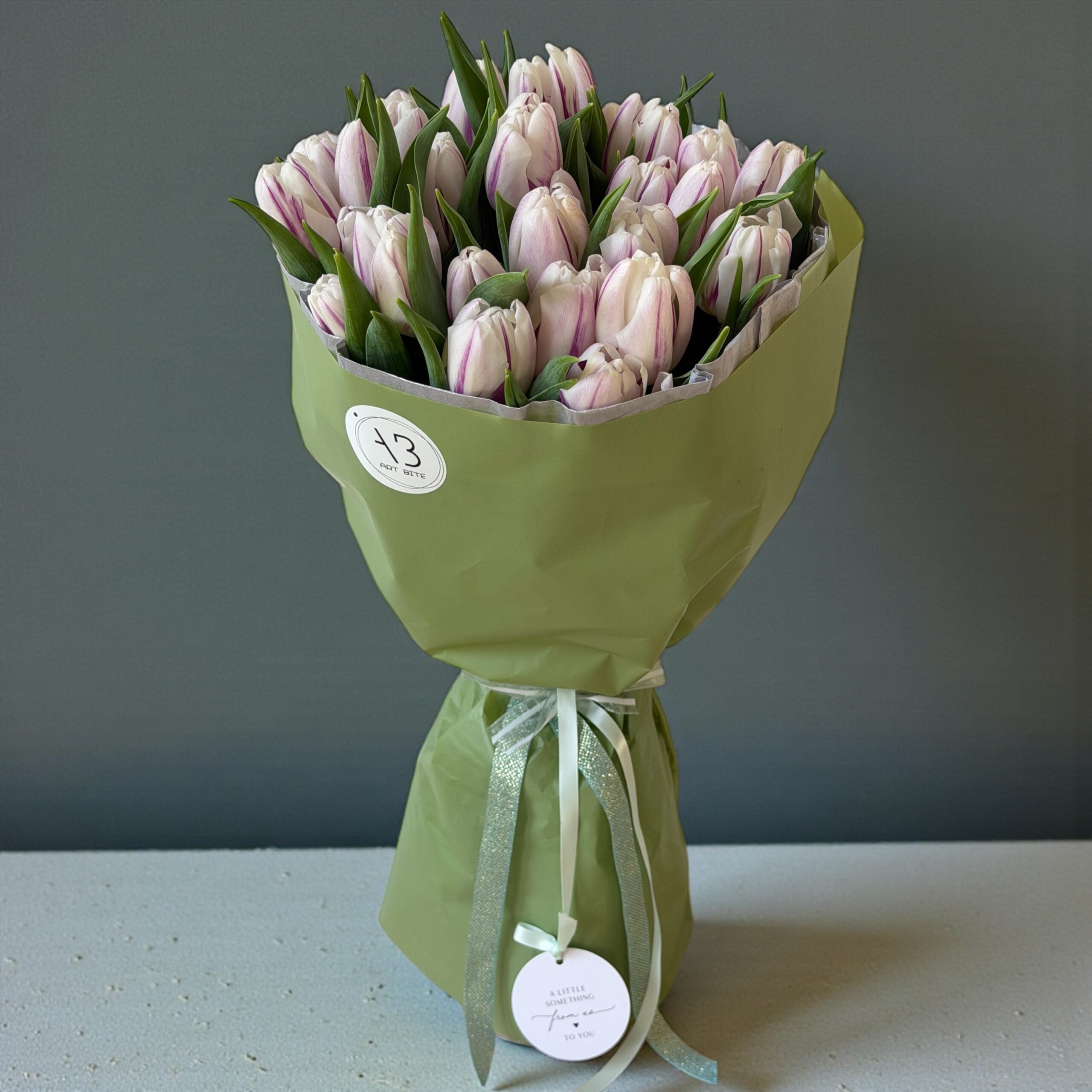 Green-toned bouquet of fresh flowers wrapped for gifting