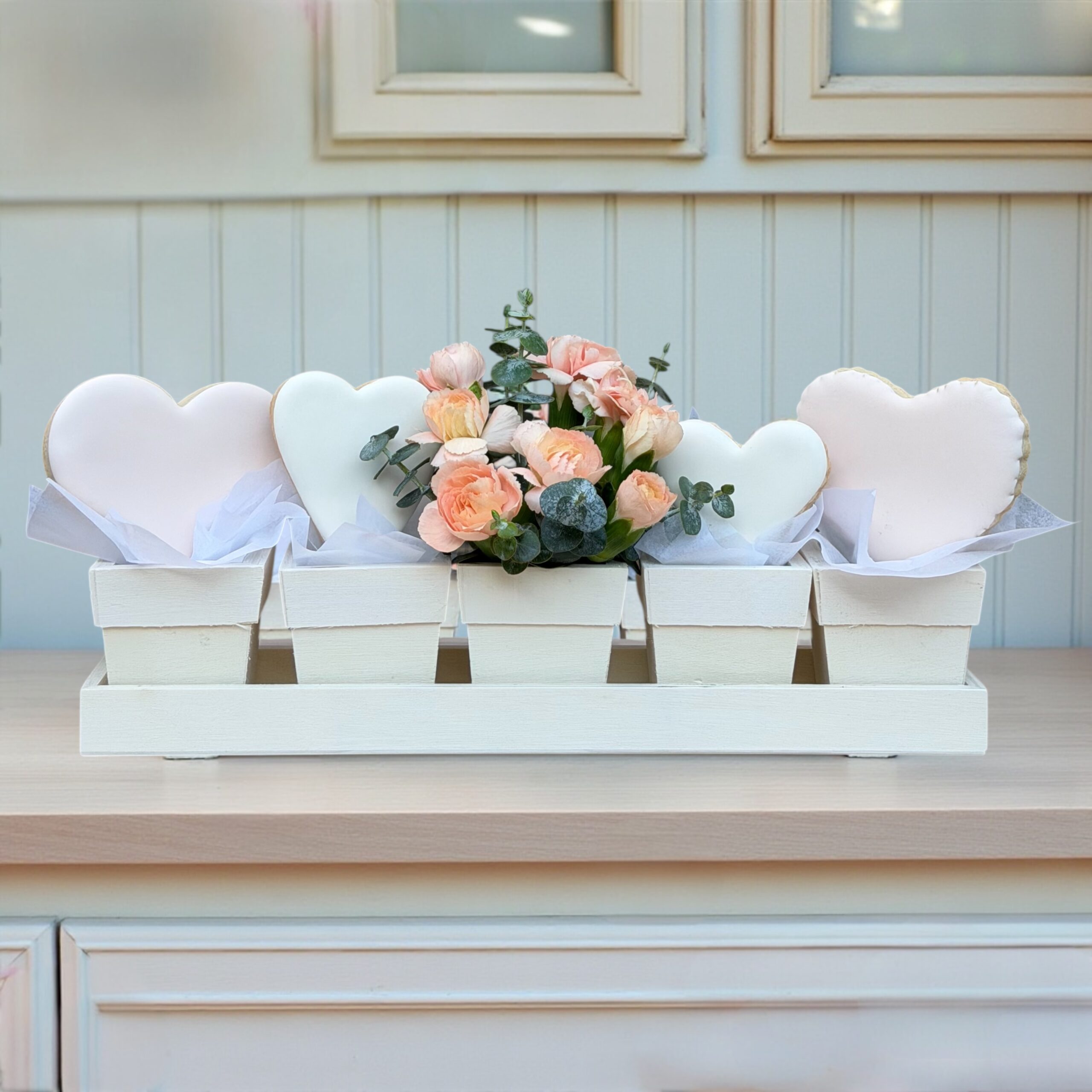 Small gift box with a decorated cookie and a single flower accent
