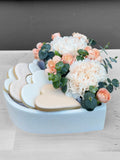 Gift box with decorated flower-shaped cookies and fresh blooms