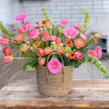Vase arrangement of wildflowers in soft purple and green tones
