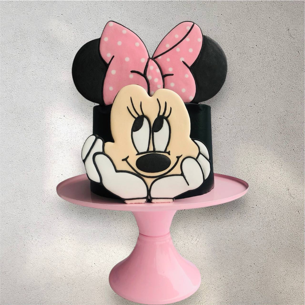 Pink Minnie Mouse-themed birthday cake with polka dot details