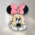 Pink decorated Minnie Mouse cookies used as a birthday cake topper