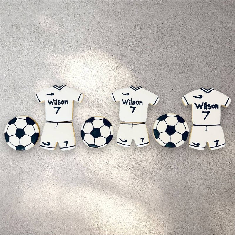Round decorated cookies iced to look like black and white soccer balls