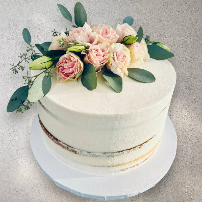 Side view of a spring-themed cake with buttercream floral decorations