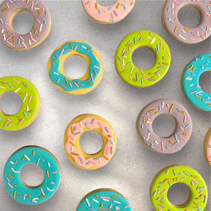 Assorted donut-shaped decorated sugar cookies with colorful icing and sprinkles
