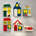 Winter house cookies with warm yellow icing windows and candy cane trim