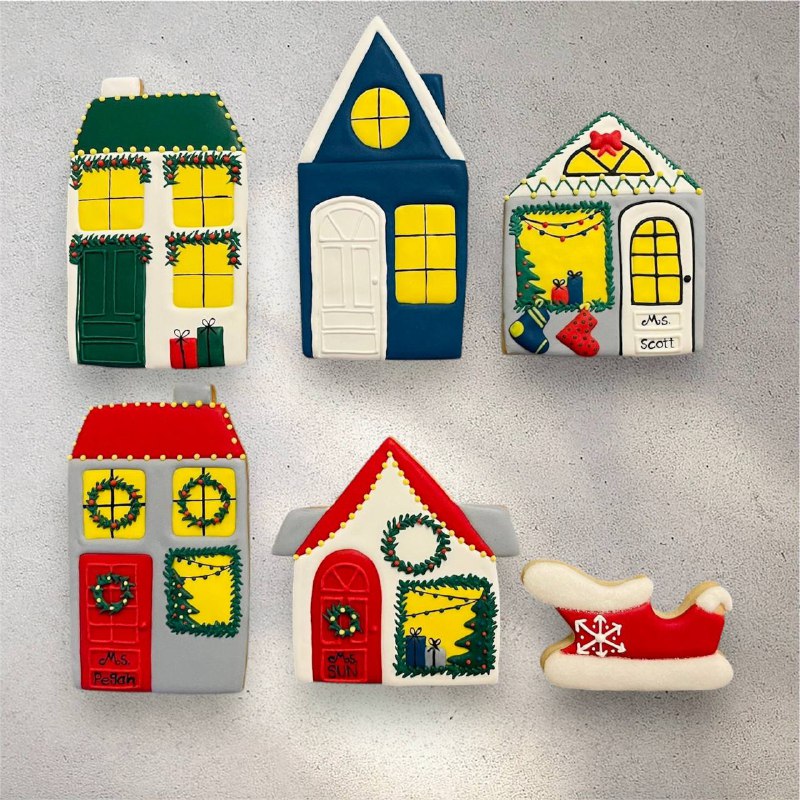 Winter house cookies with warm yellow icing windows and candy cane trim