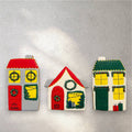 Gingerbread house cookies decorated with white icing snow on the rooftops