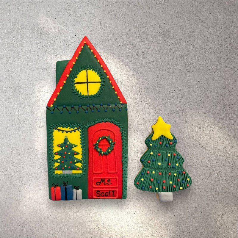 Decorated gingerbread house cookie with white icing snow on the roof