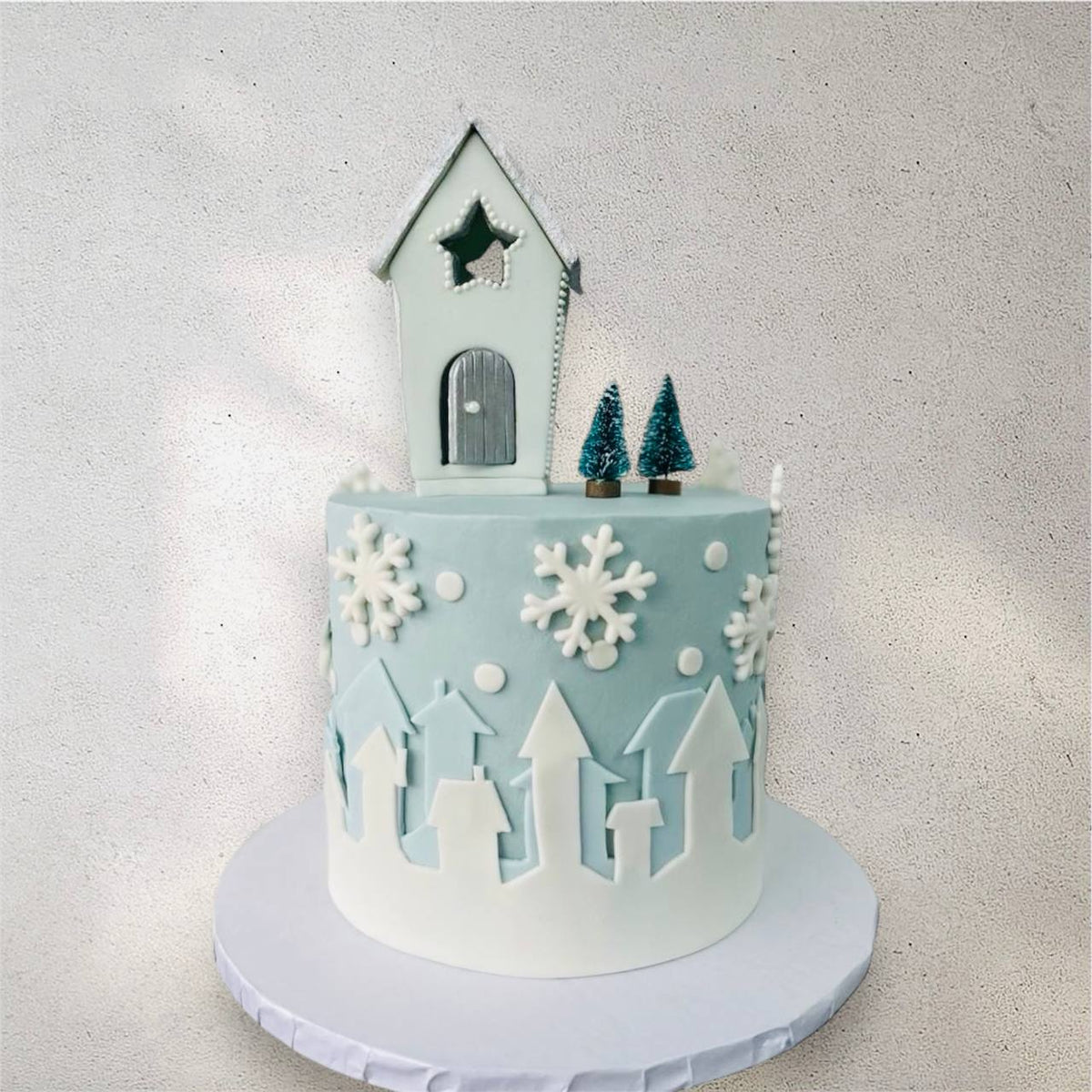 White holiday cake decorated with snowy winter details
